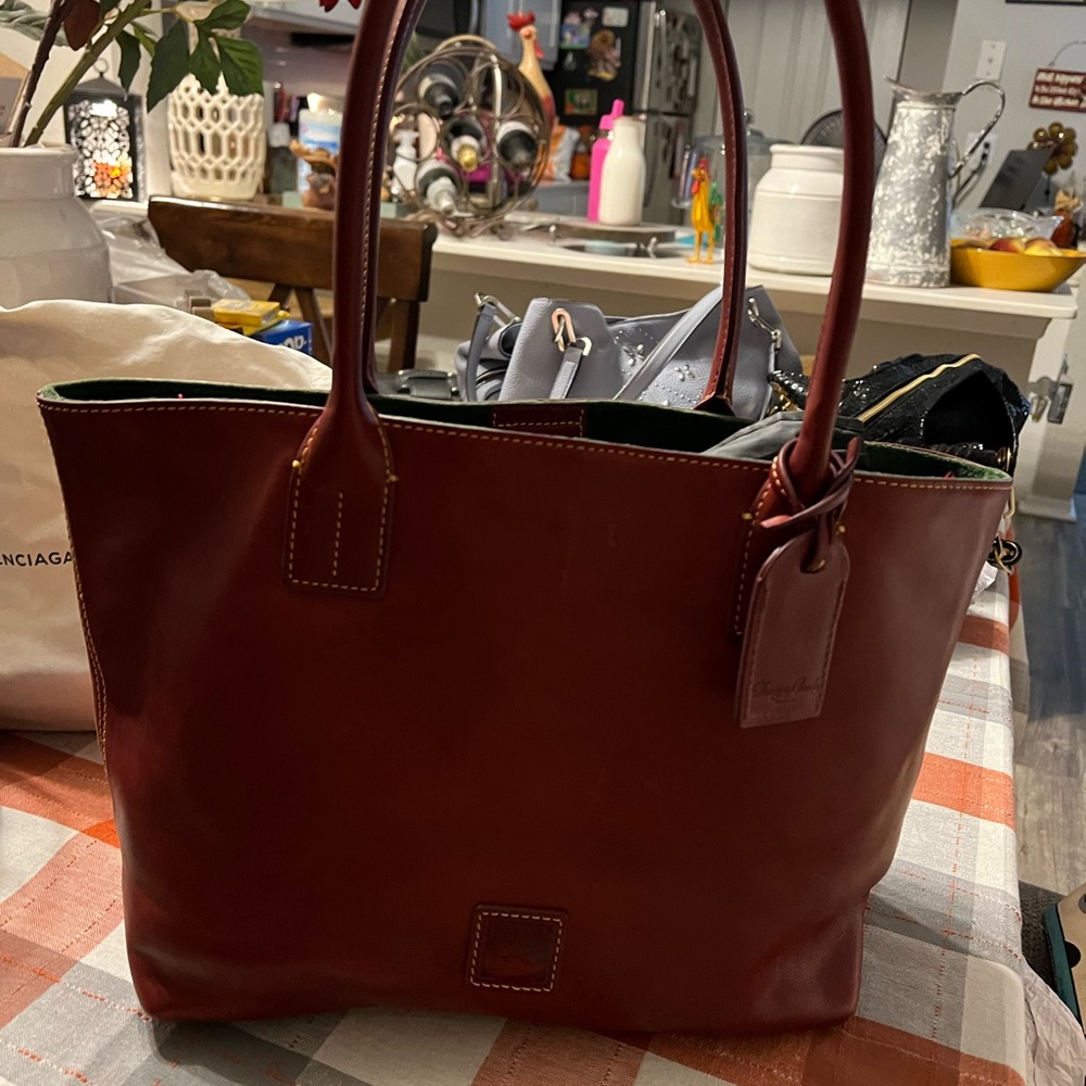 This beautiful burgundy Dooney and Bourke shoulder bag is absolutely gorgeous